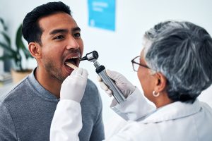 Doctor with patient examining mouth for cancer