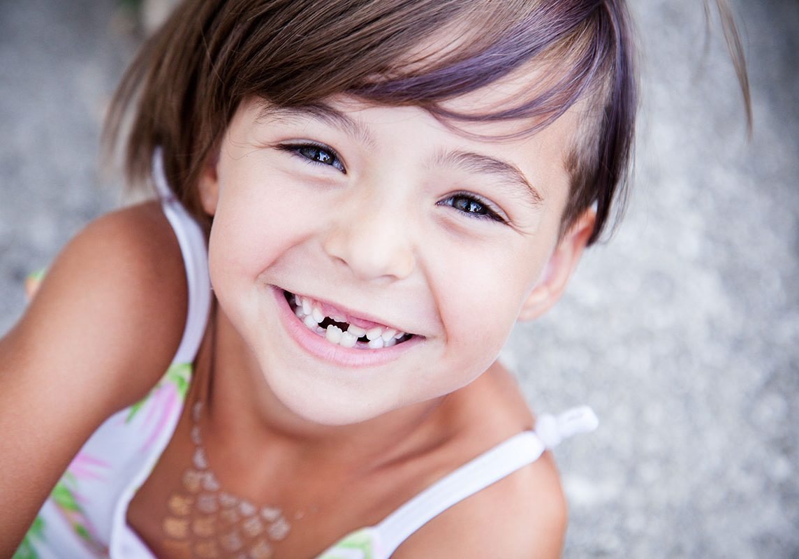 Girl with big smile and missing milk teeth